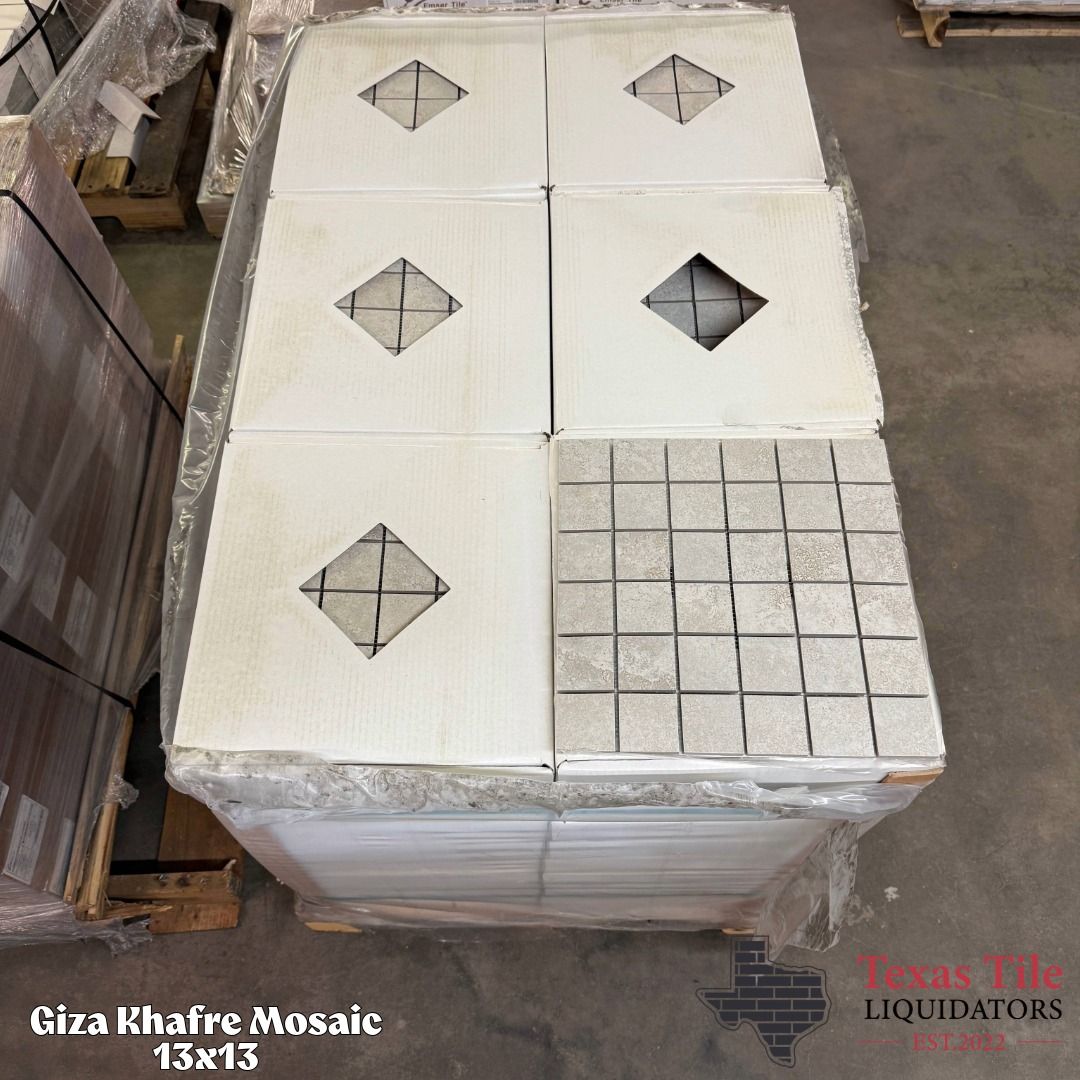 Stacked white mosaic tiles on a pallet, some with diamond cutouts and one grid-patterned tile