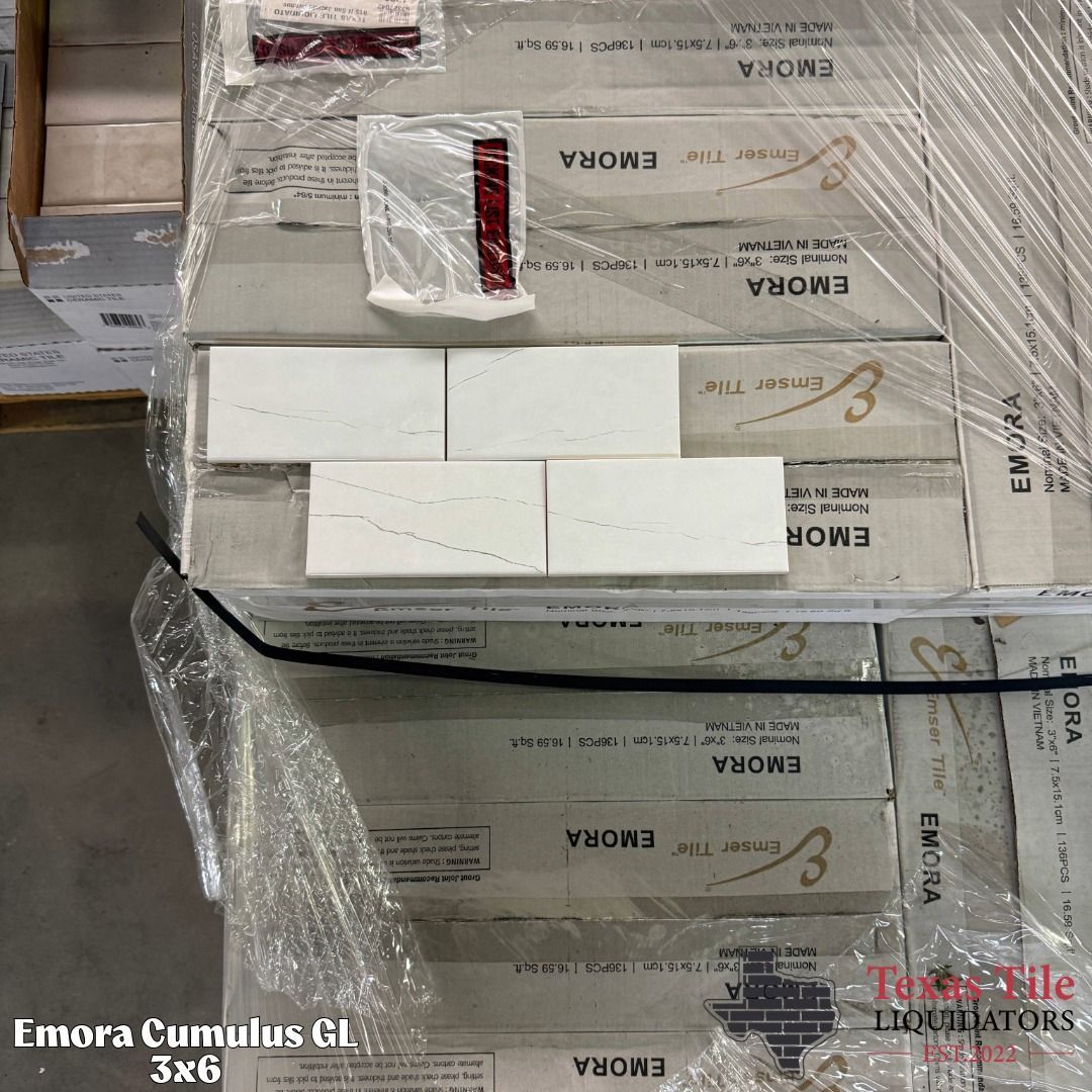 Stacked white and beige product boxes wrapped in plastic, viewed from above in a warehouse-like setting