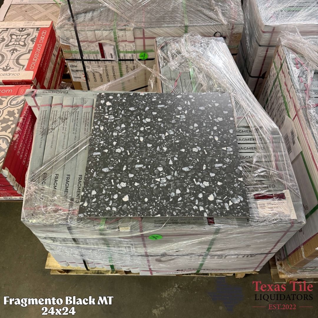 Pallet of wrapped black speckled tile boxes with sample tile on top in warehouse shipment area