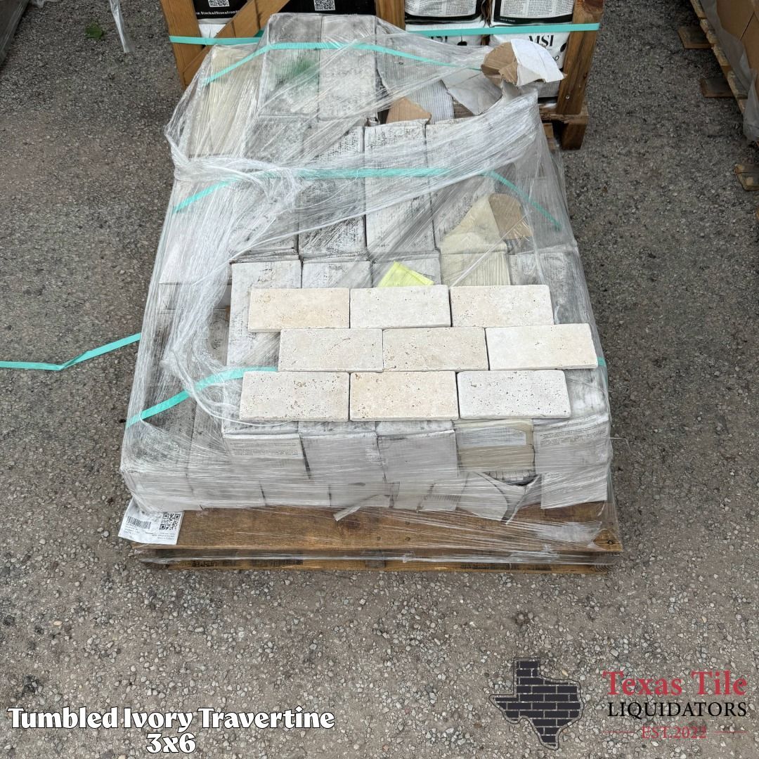 Pallet of stacked light-colored bricks wrapped in plastic and strapped with teal bands on gravel.