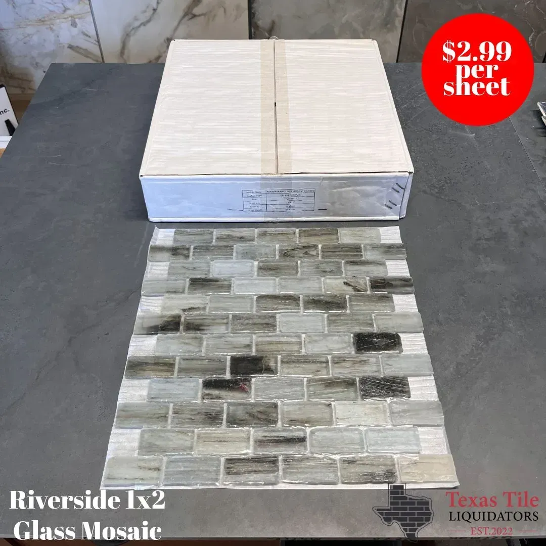 A box of Riverside 1x2 glass mosaic tiles with varied gray and white tones, priced at $2.99 per sheet at Texas Tile.