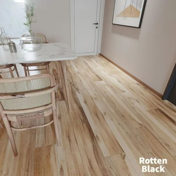 Light-colored wood flooring in a dining area featuring a marble table and chairs, with a white door and art on the wall.