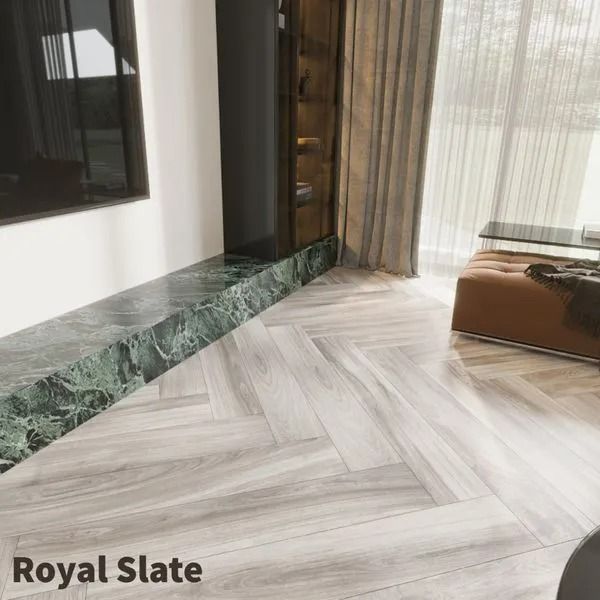 Herringbone-patterned light grey wood flooring next to a green marble hearth in a modern living space.