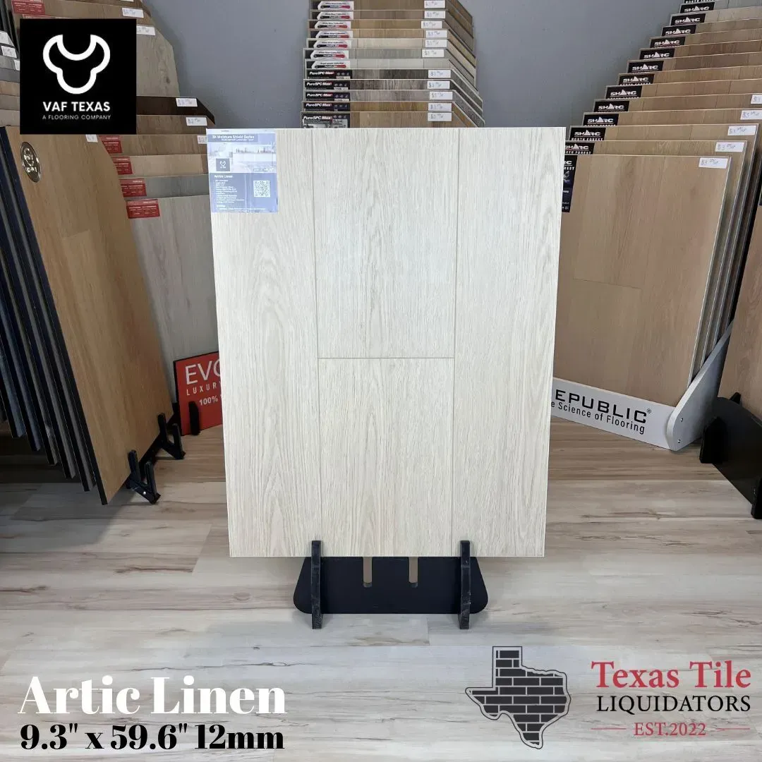 Large light beige tile display on a stand in a tile showroom, with sample racks in the background.