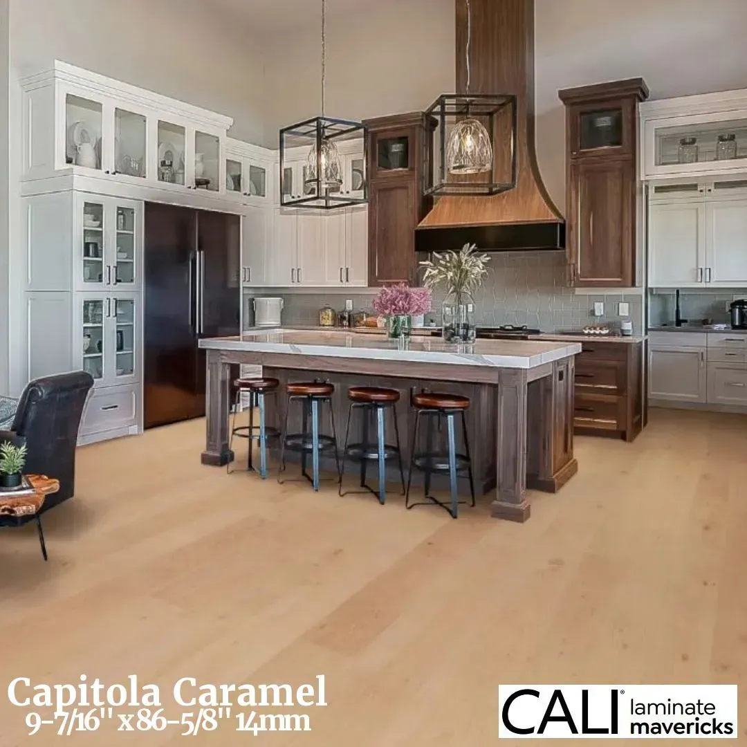 A kitchen with white cabinets, a dark wood island and hood, and light-colored laminate flooring titled Capitola Caramel.