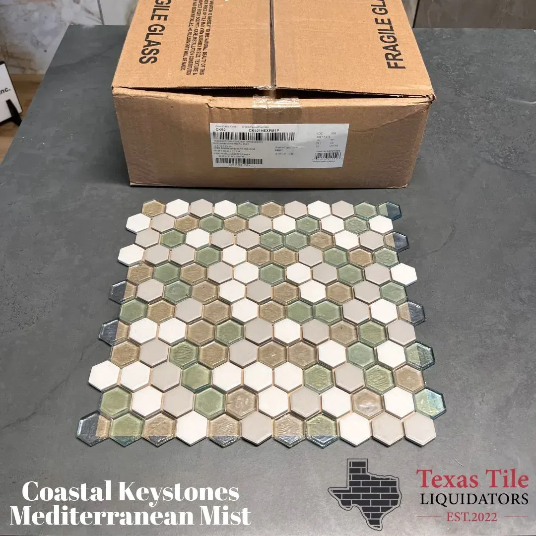 A sample sheet of Mediterranean Mist hexagonal glass tiles in shades of green, white, and tan, with a box and logo.