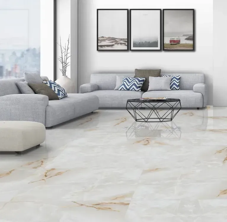 A living room with gray sectionals, a geometric coffee table, and three framed prints on a white wall over tile floors.
