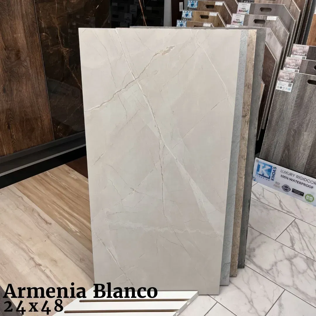 A display of large, rectangular, light-gray marble-look tiles labeled