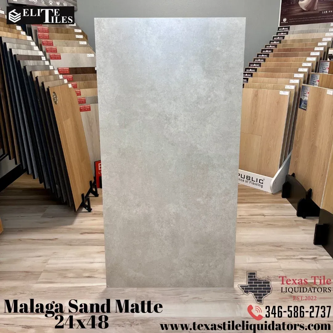 A large, grey, rectangular matte tile displayed in a showroom with tile samples in the background.