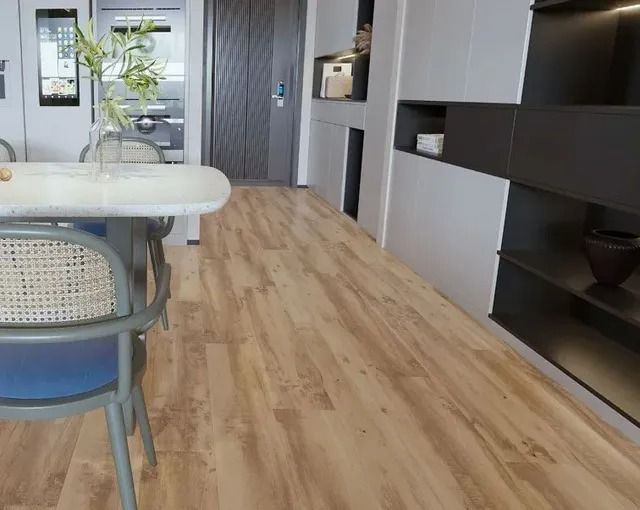 A modern interior room with light wood-patterned flooring, a white dining table with a chair, and dark shelving units.