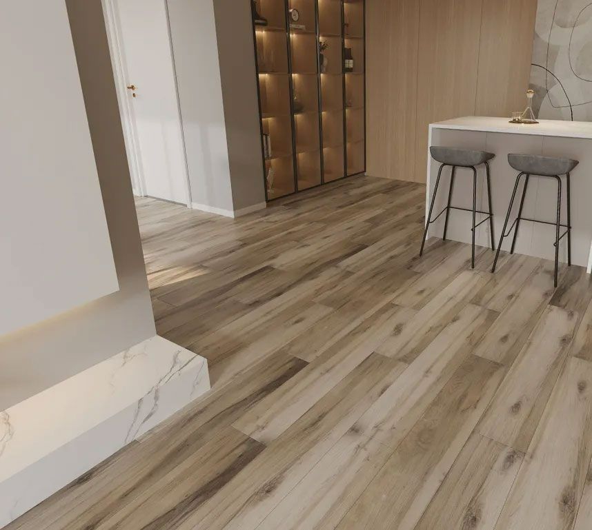 Modern interior with wood-look flooring, a kitchen island with two gray stools, and an illuminated glass display cabinet.