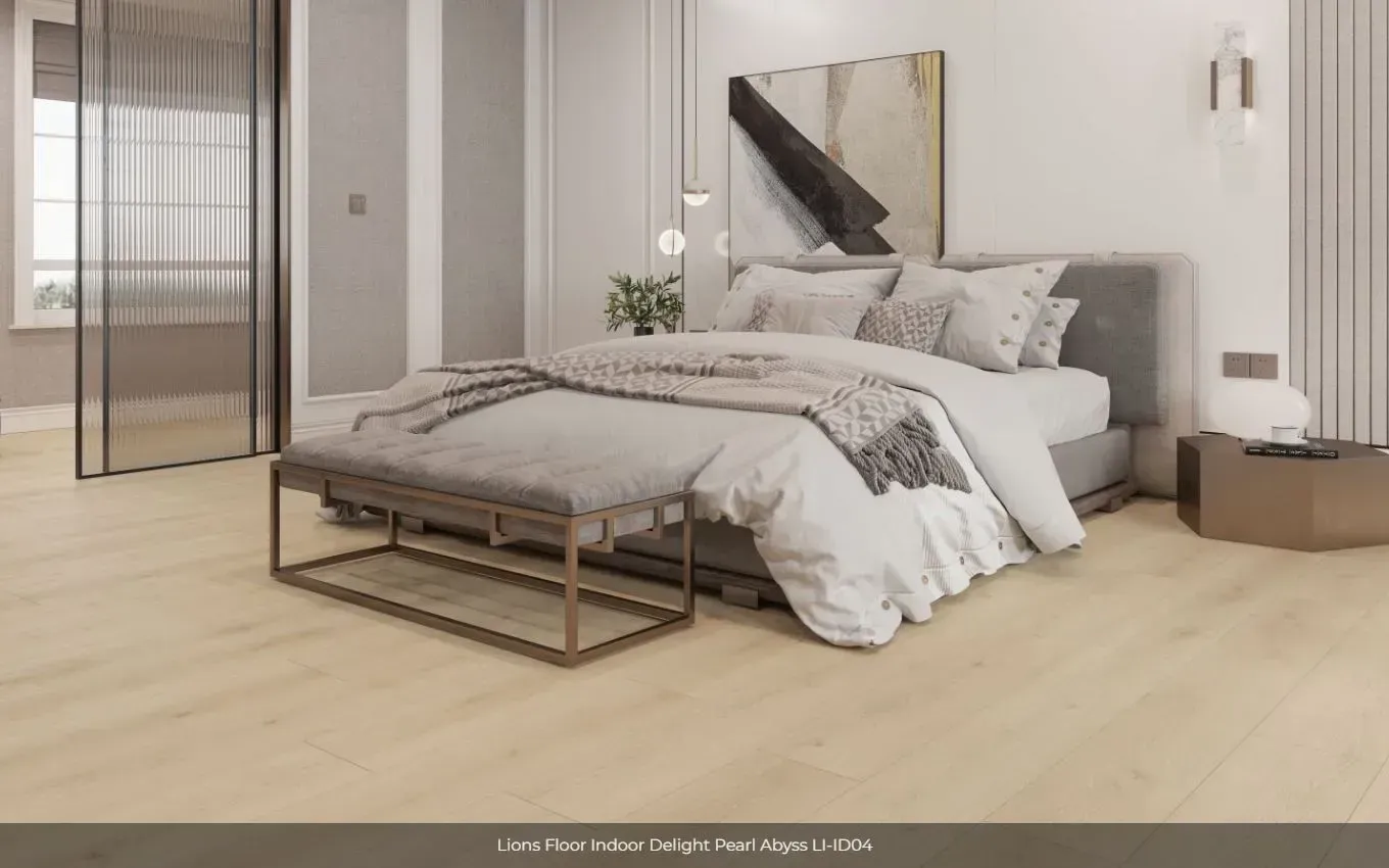 A modern bedroom with light wood floors, a grey bed with a bench at the foot, and abstract wall art.
