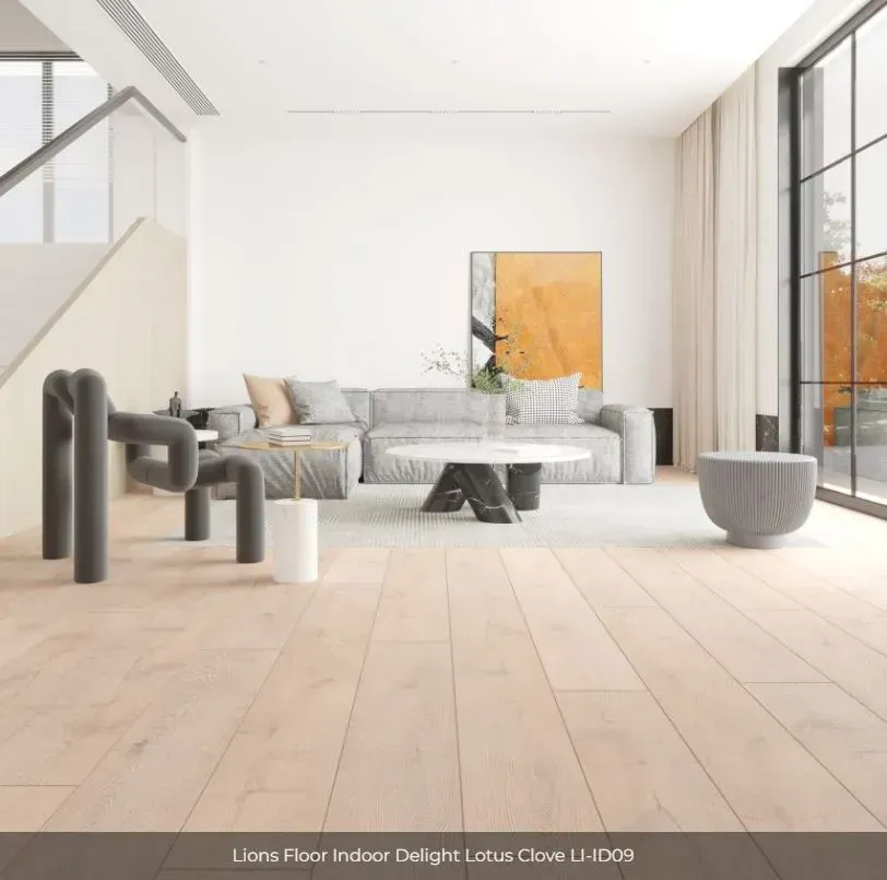 A bright, modern living room with light oak wood flooring, a grey sofa, and a sculptural armchair.