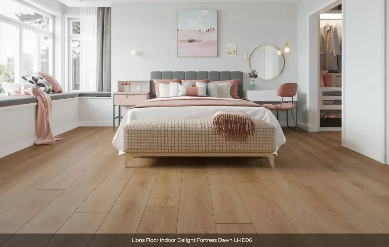 A modern, light-filled bedroom with hardwood floors, a plush bed with a pink throw, and a walk-in closet.