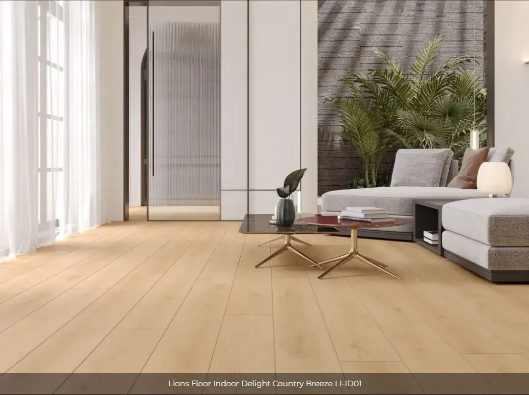 A modern living room with light oak flooring, a neutral-toned sectional sofa, a small coffee table, and a potted plant.