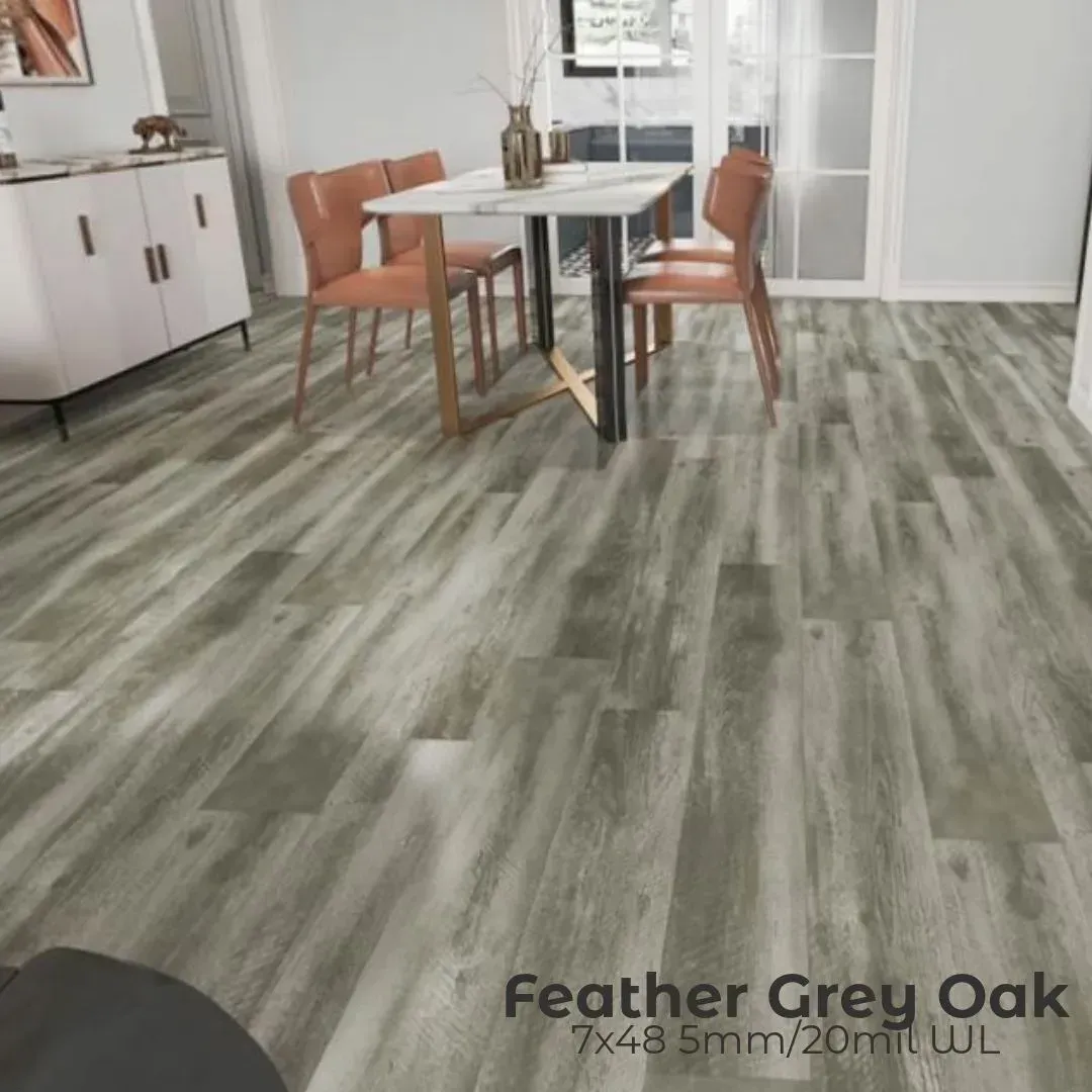 A room featuring Feather Grey Oak wood-look flooring, with a dining table and chairs in the background.