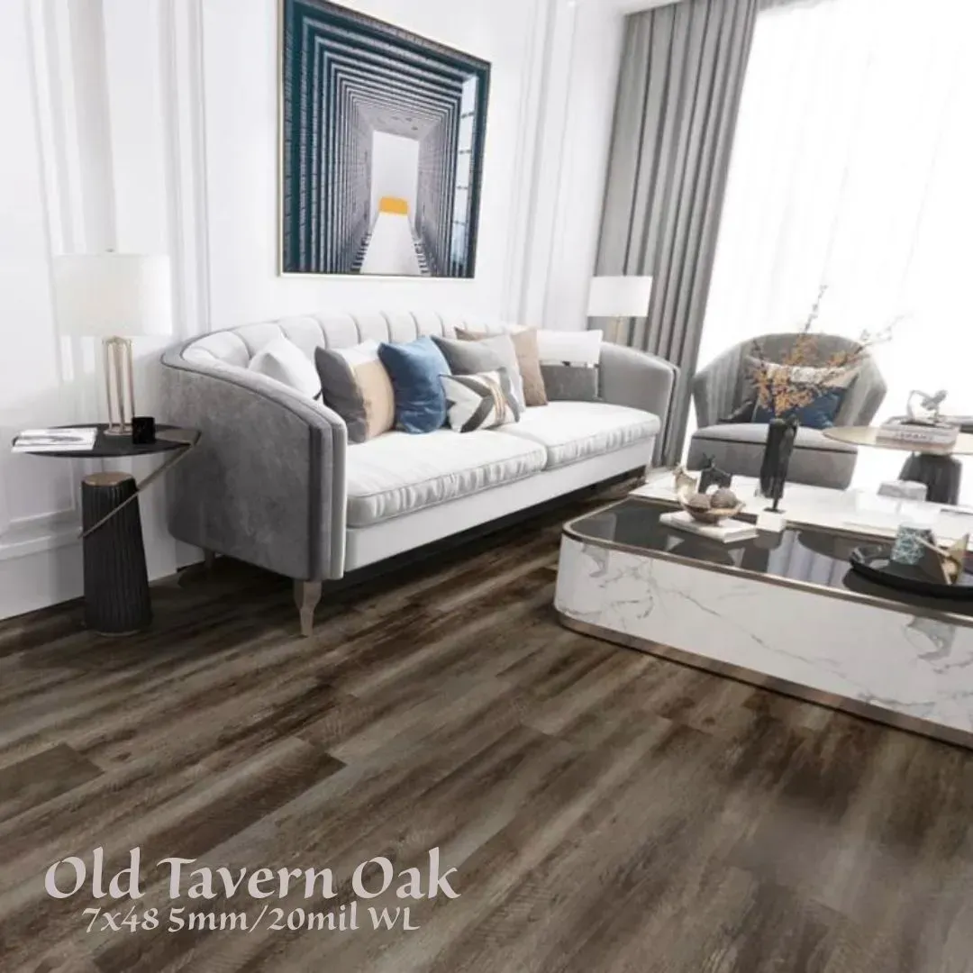 Modern living room with gray sofa, blue pillows, white decor, and wood-look flooring