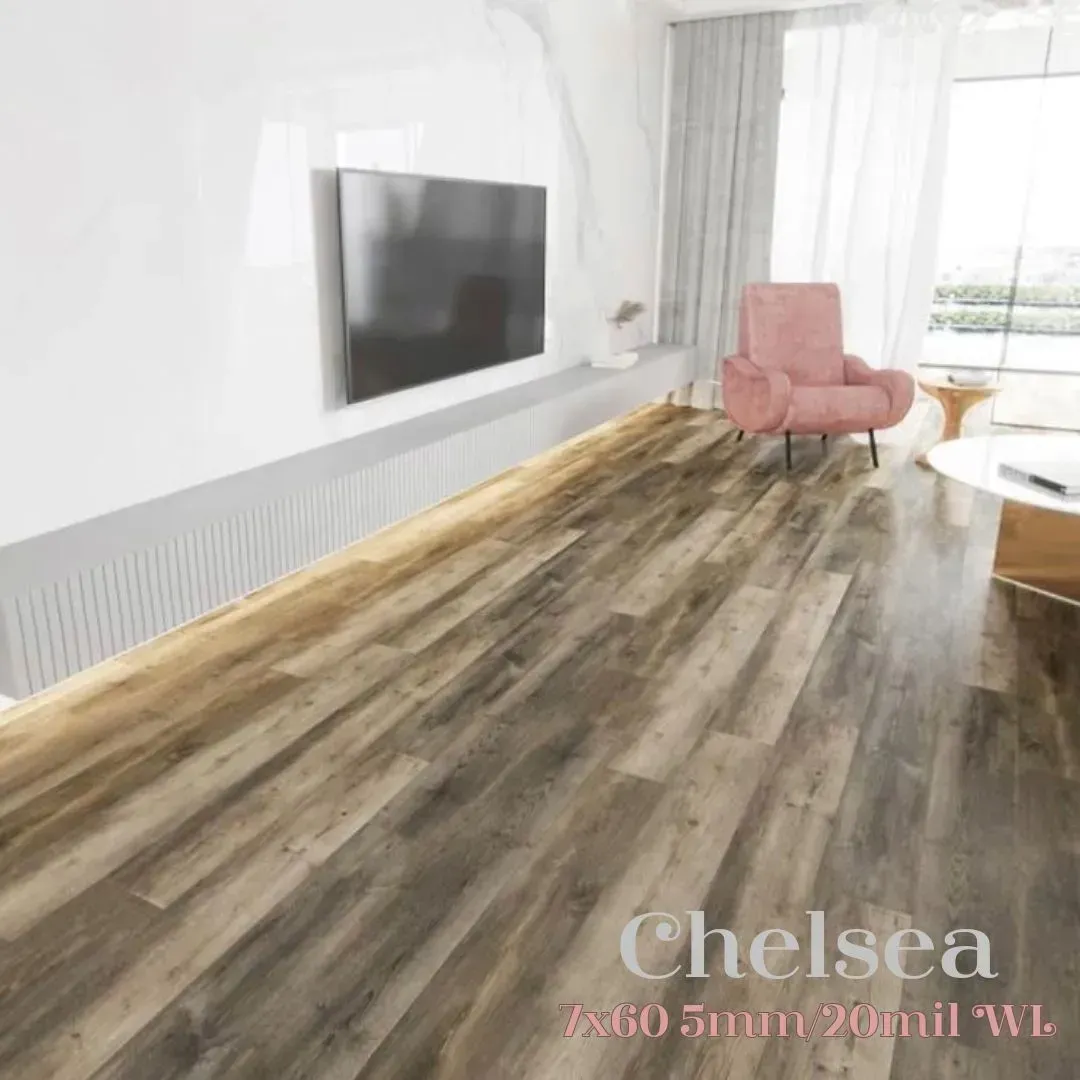 A living room featuring wood-look flooring, a wall-mounted TV, and a pink armchair by a window with sheer curtains.