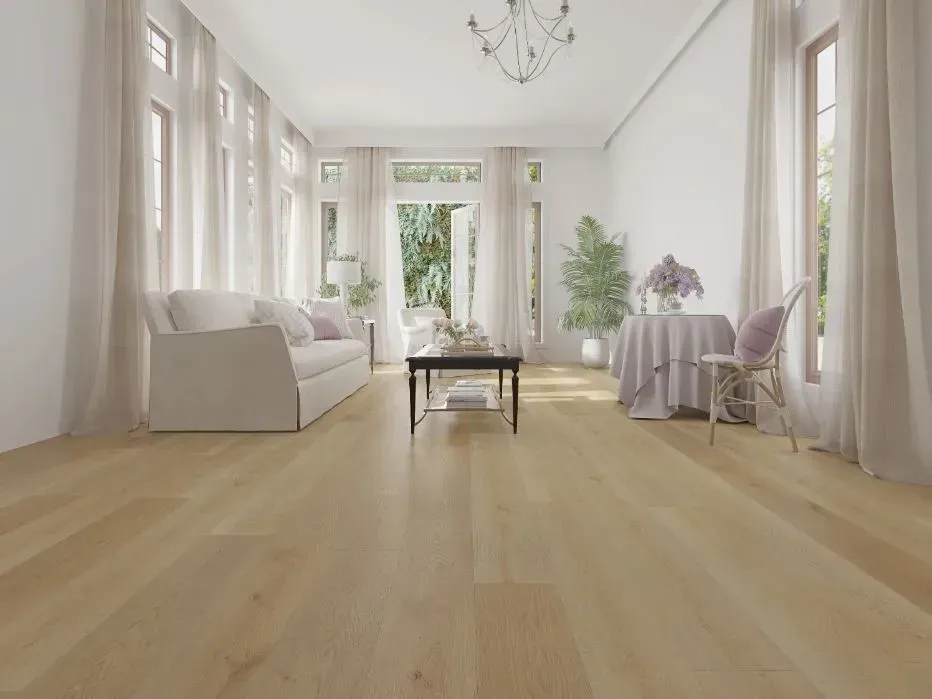 A bright living room with light hardwood floors, a white sofa, a center coffee table, and a small round dining table.