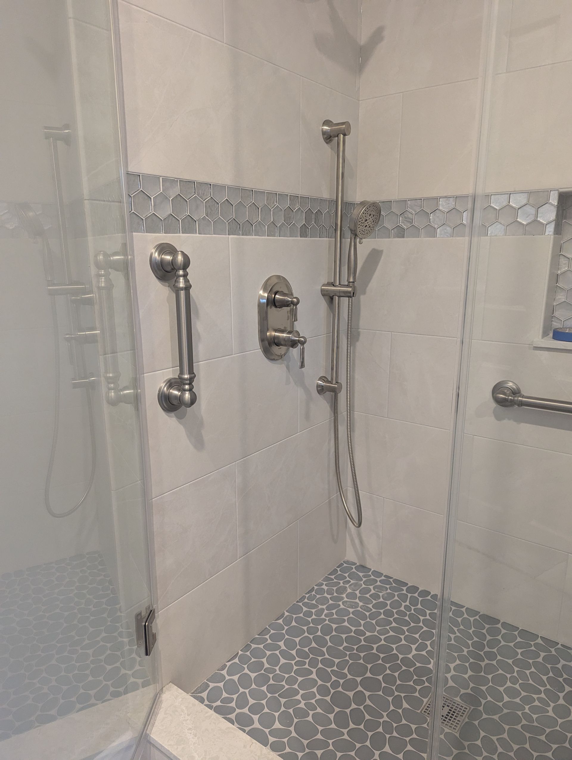 A bathroom with a walk in shower and a glass door.