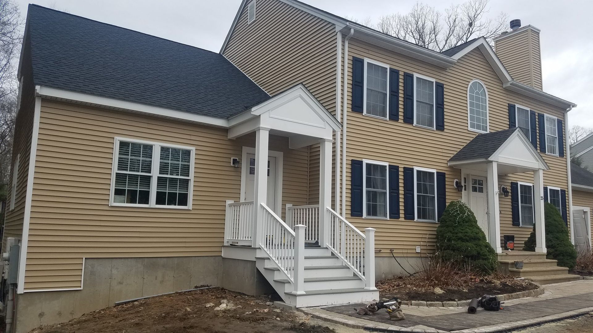 A large house with a porch and stairs in front of it.