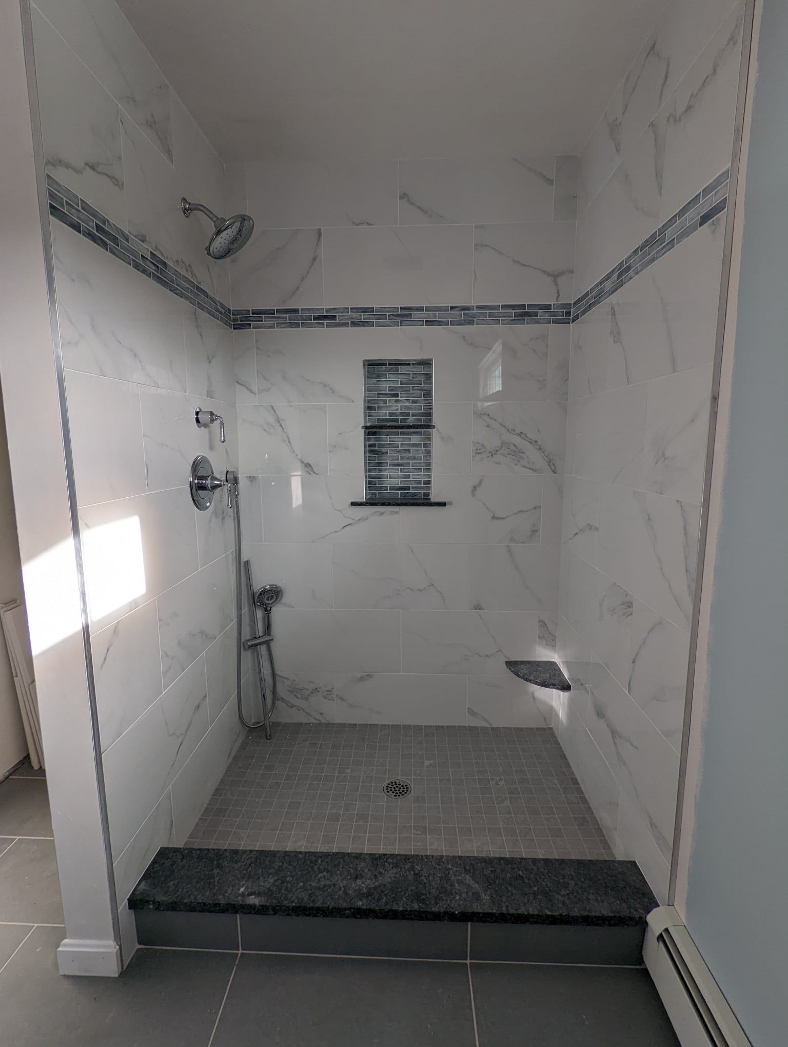 A bathroom with a walk-in shower and a sink.