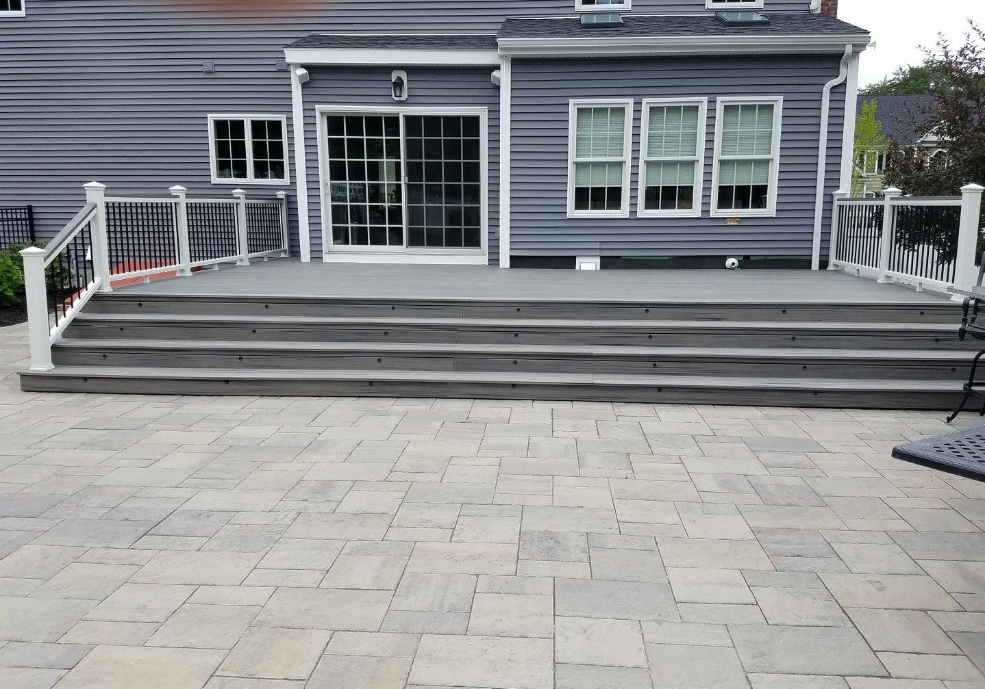 A large patio with stairs leading up to a large house.
