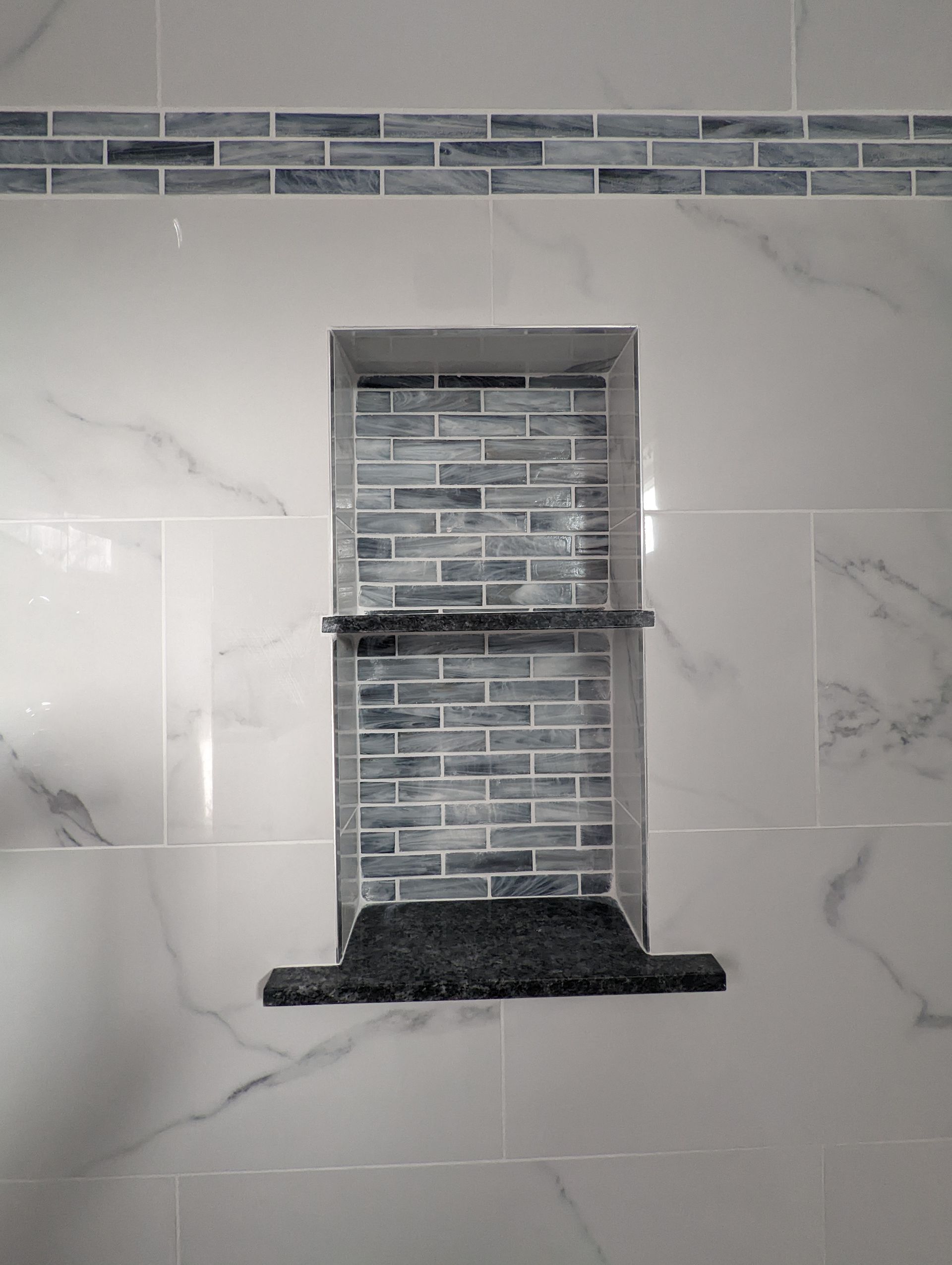 A shower niche with a shelf in a bathroom.