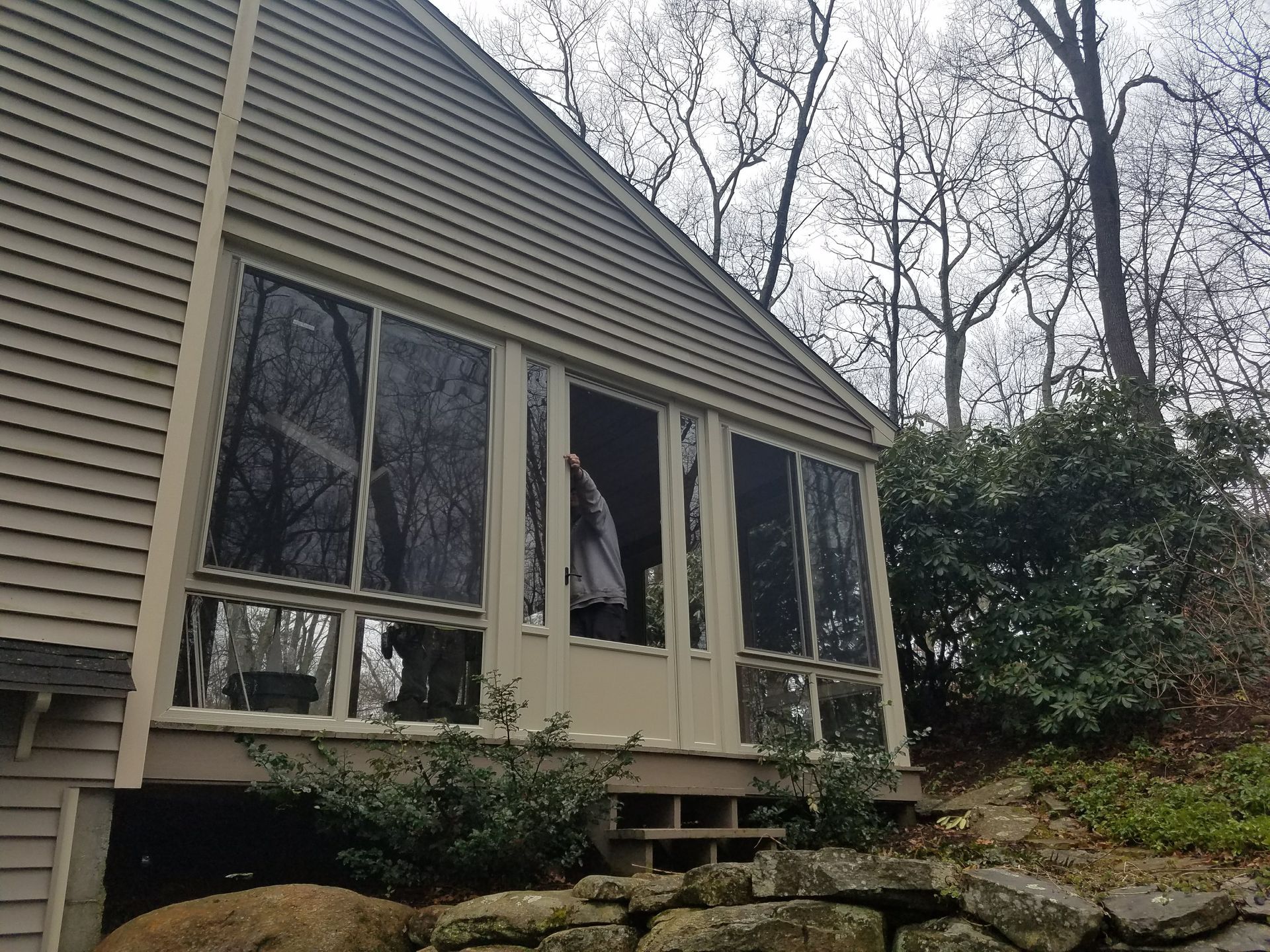 A house with a screened in porch and trees in the background
