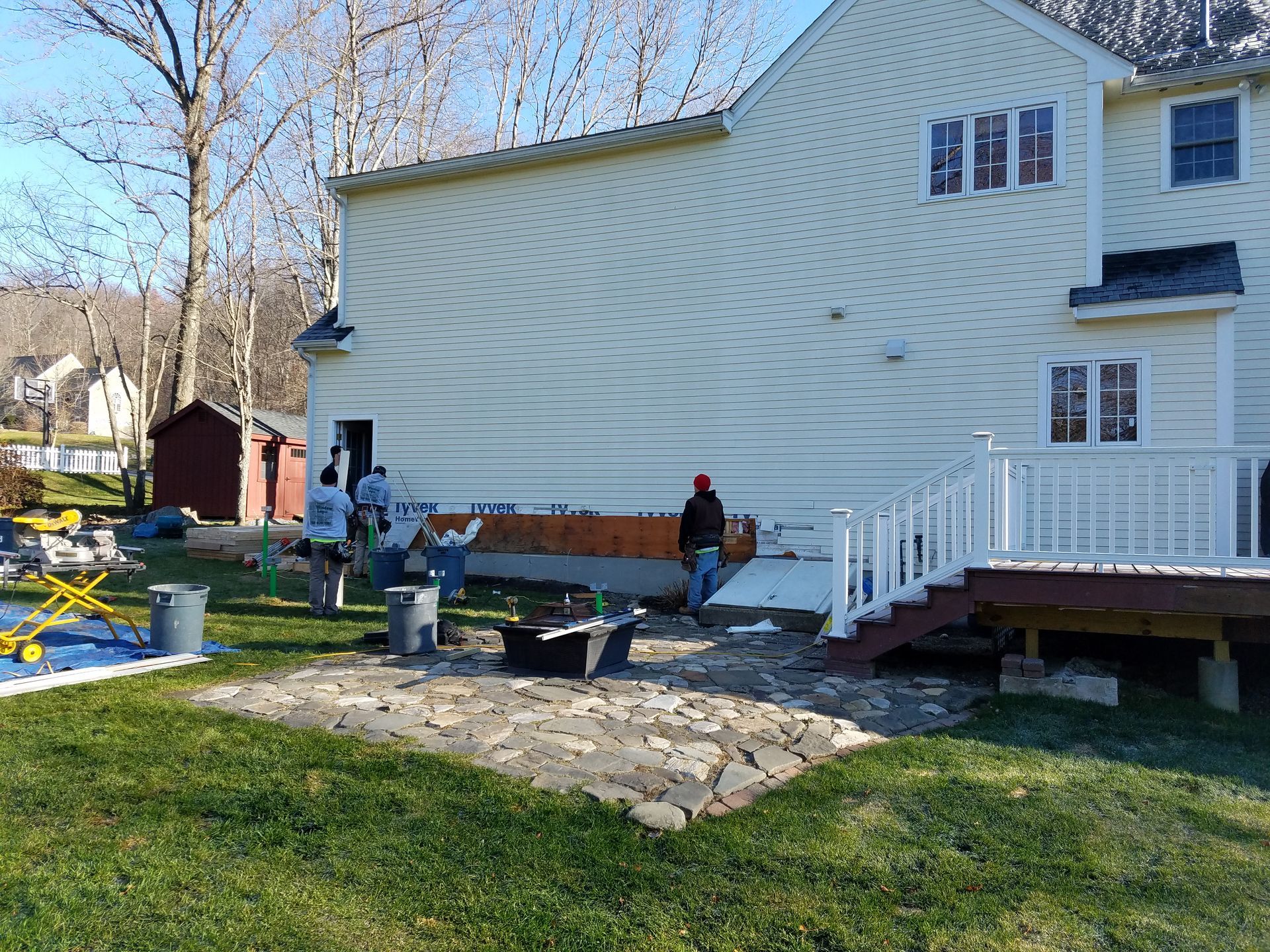 A group of people are working on the side of a house.