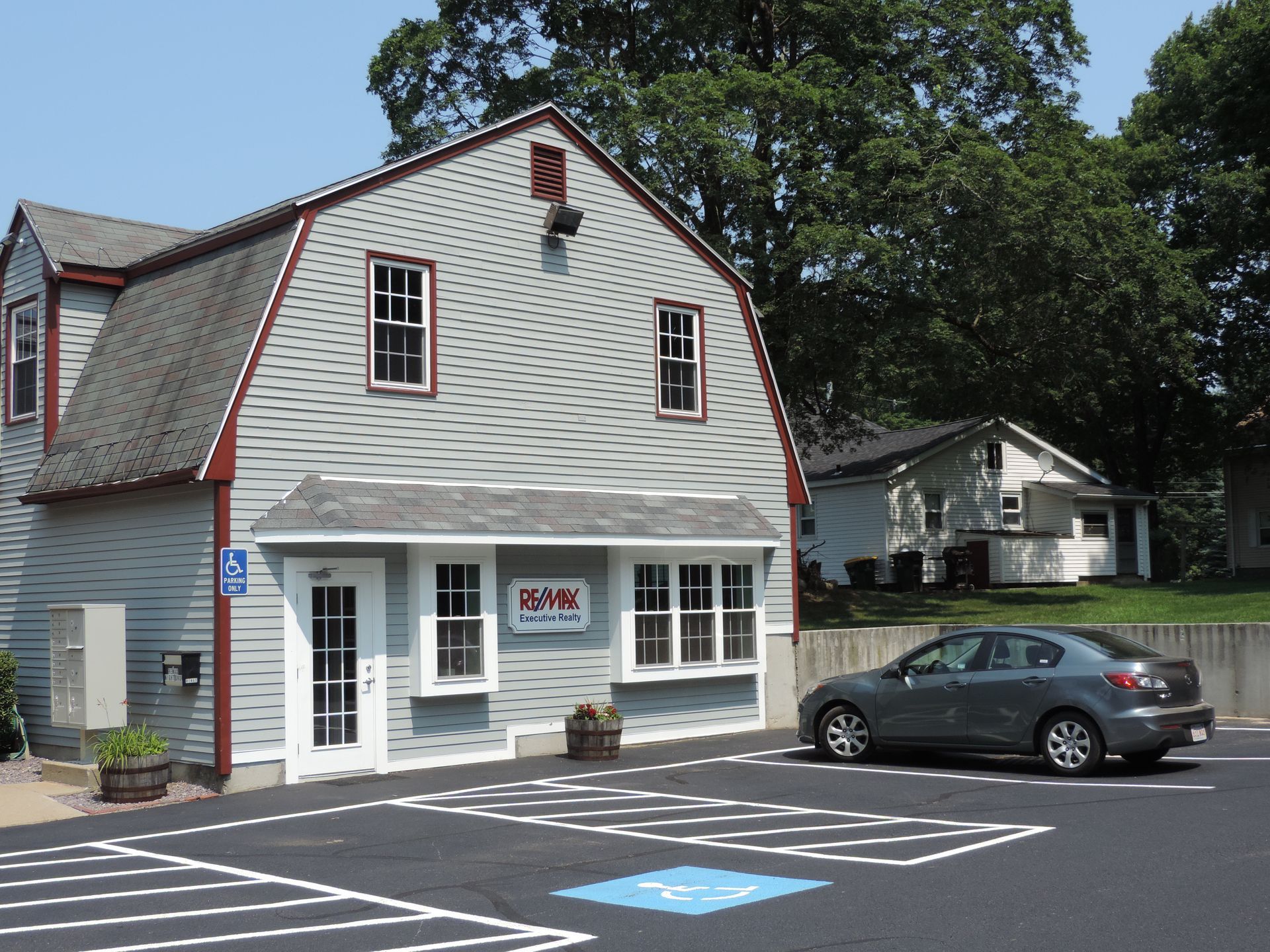 A car is parked in front of a building that says real estate