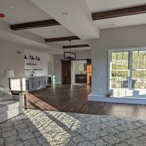 A living room with hardwood floors, a couch, and a rug.
