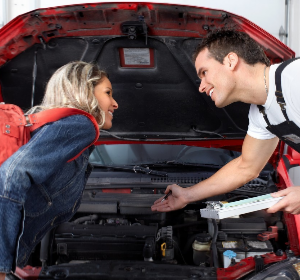 Male and female inspecting a car transmission