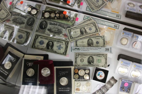 A variety of coins and bills are displayed on a table.