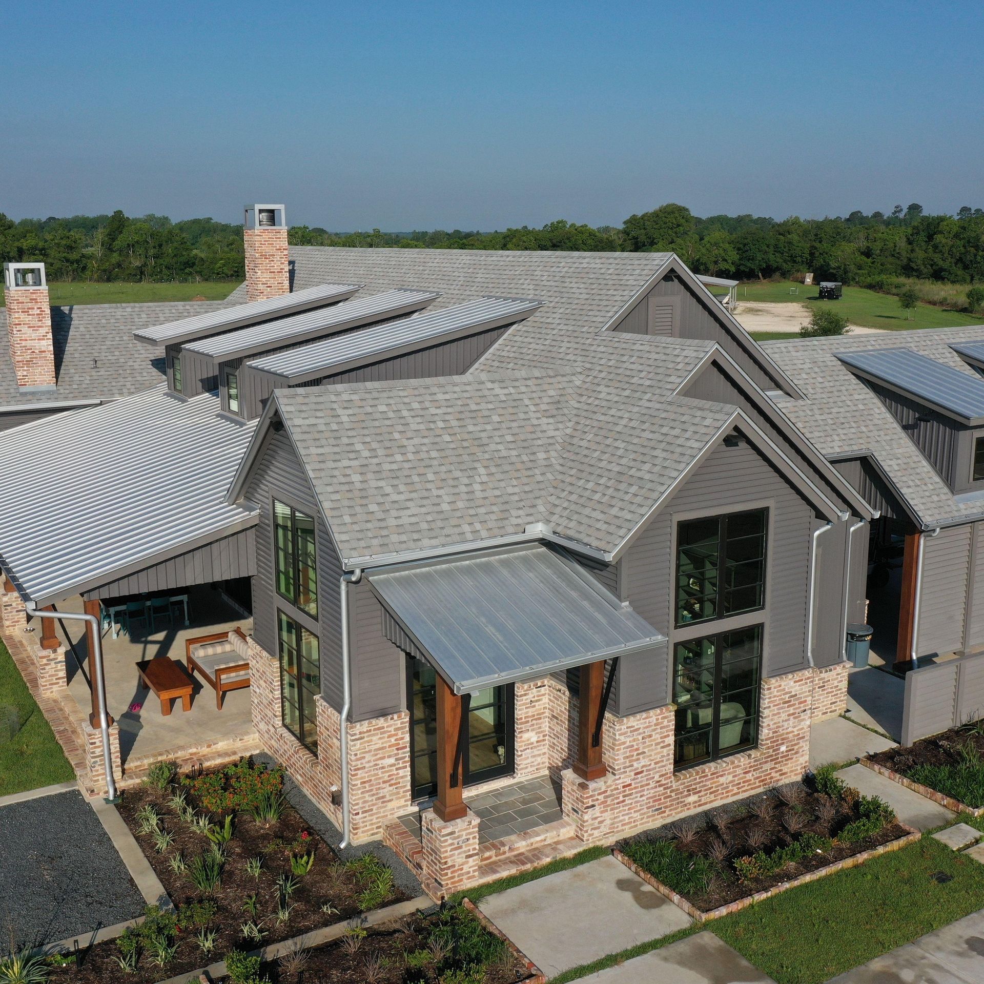 Modern house with gray roof, brick and gray siding, and metal accents.