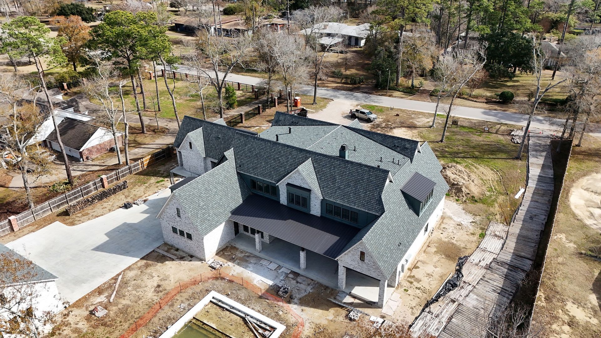 Aerial view of a modern two-story house with a dark gray roof and white exterior.