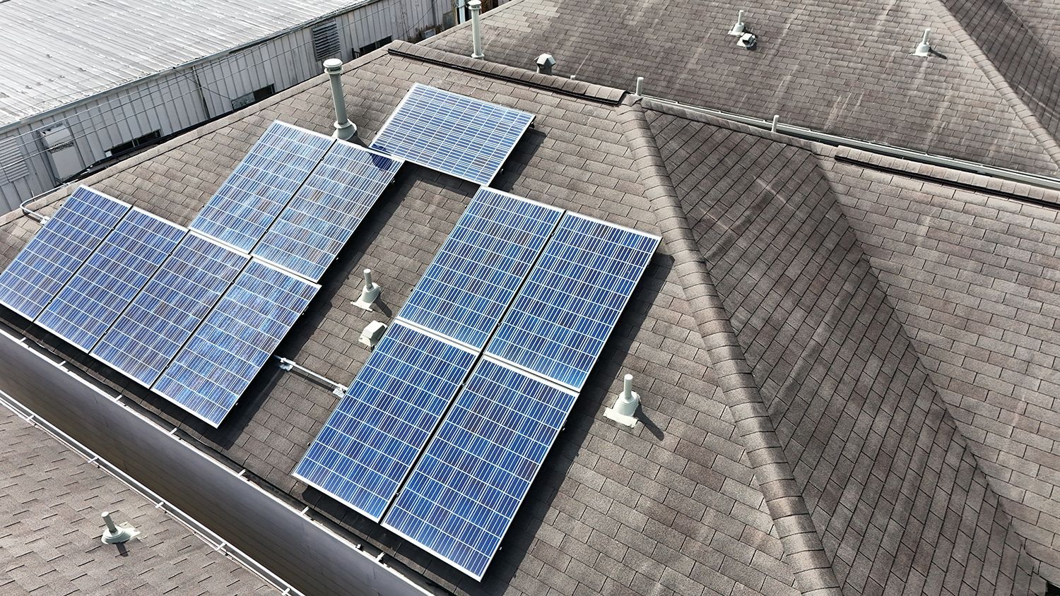 Solar panels installed on a dark rooftop.