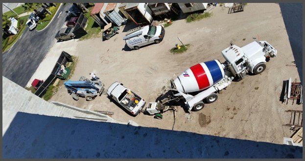 Aerial view of cement mixer and pickup truck on job site