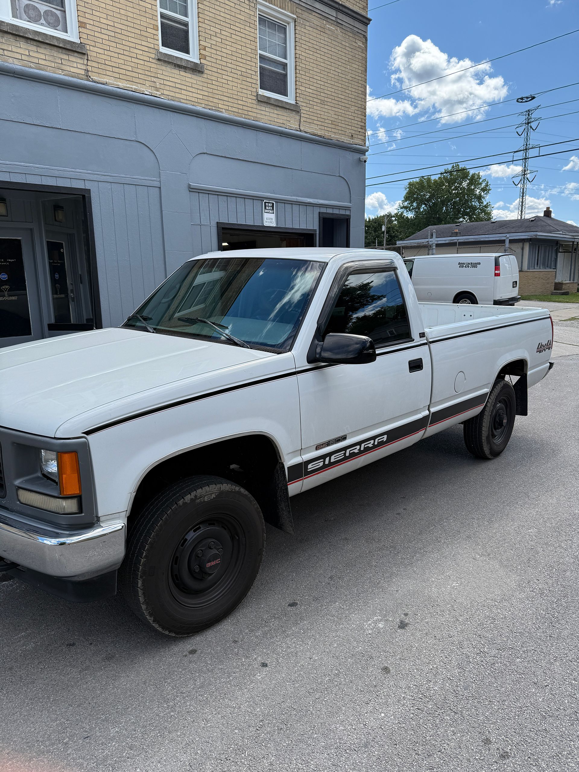 White GMC pickup truck parked outside a building.