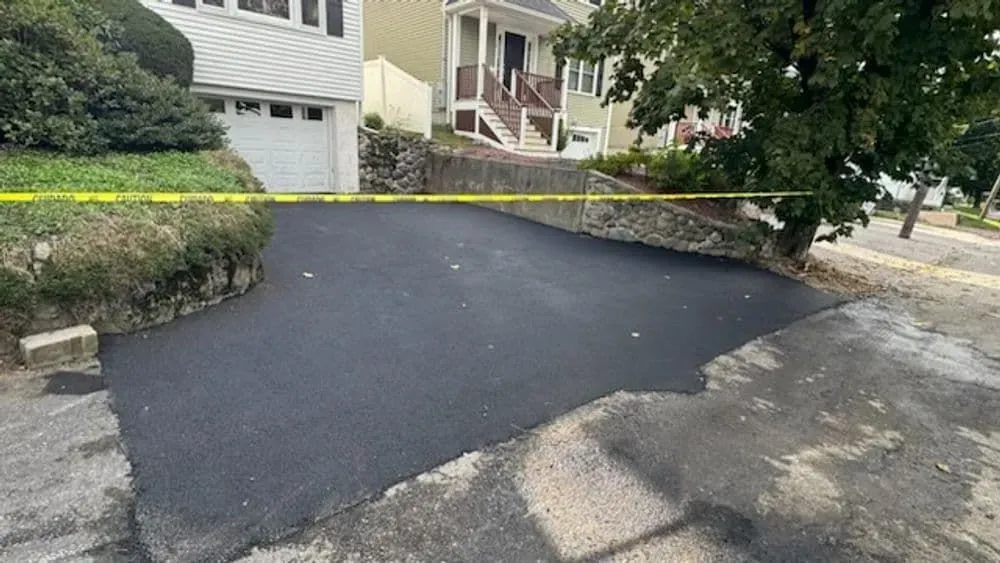 A newly paved driveway in front of a house.