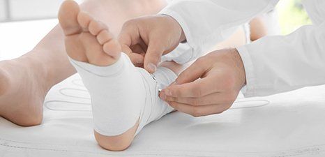 Doctor applying bandage onto patient's foot