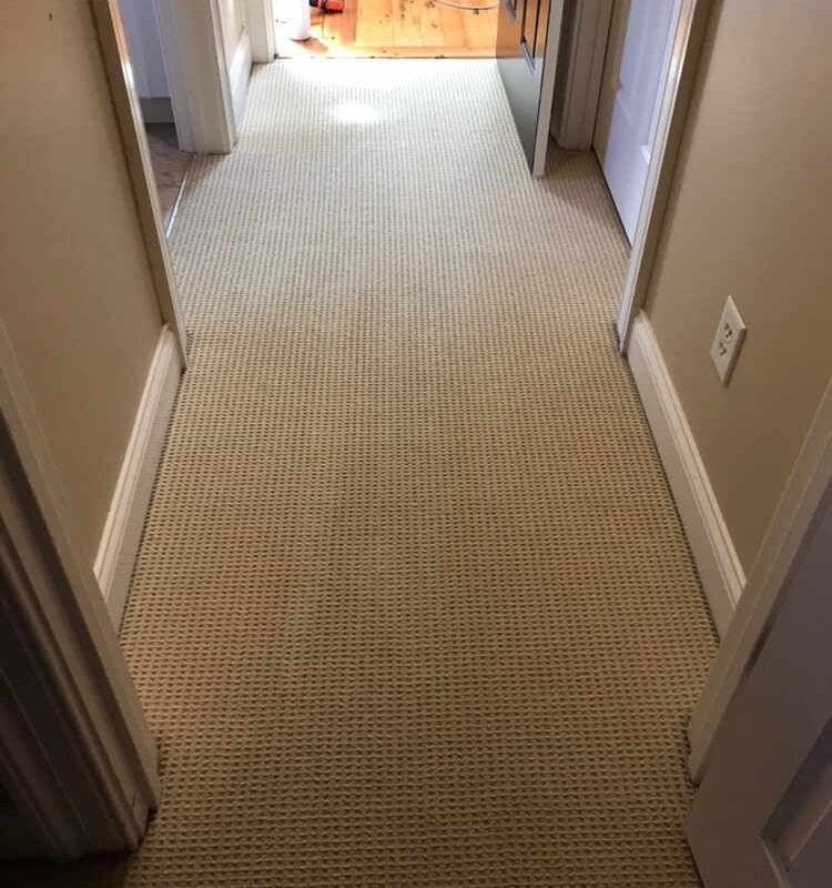 A hallway with a carpeted floor and white trim - after