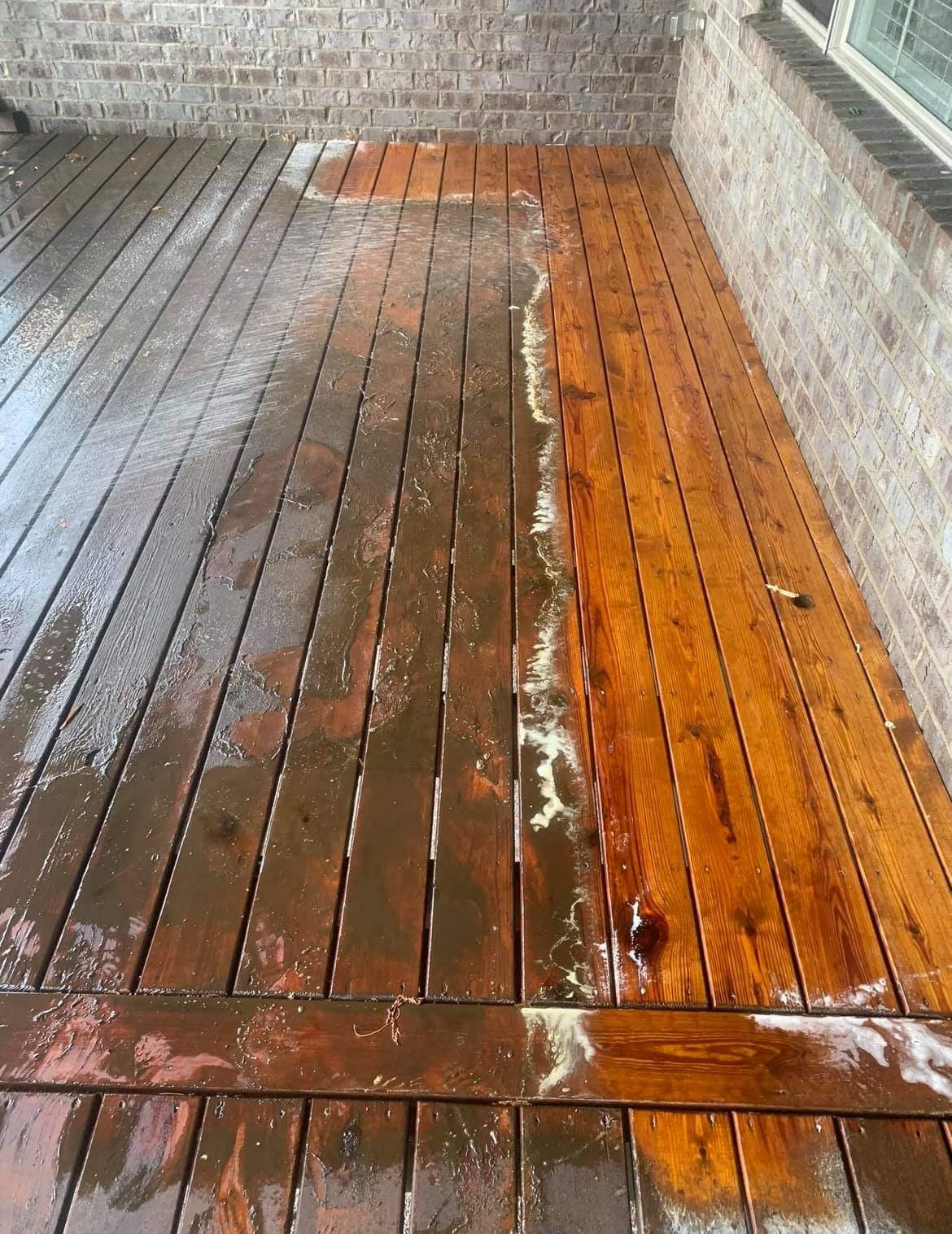 A wooden deck with a brick wall in the background.