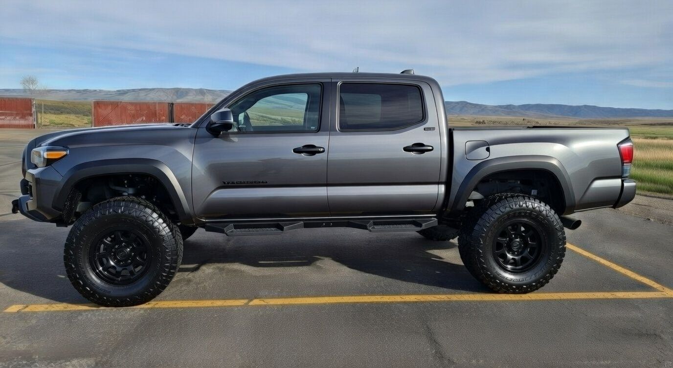 Gray pickup truck with black wheels parked on asphalt