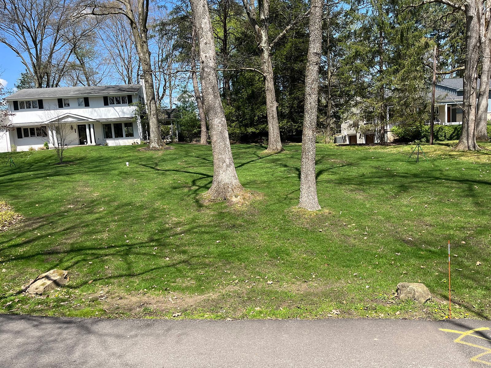 A house is sitting on top of a lush green hill surrounded by trees