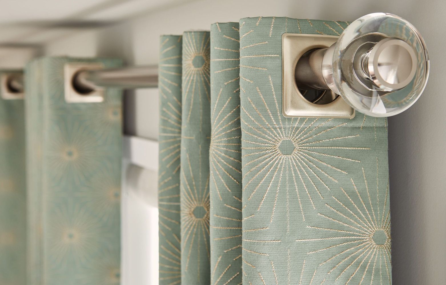 A close up of a pair of curtains hanging on a window.