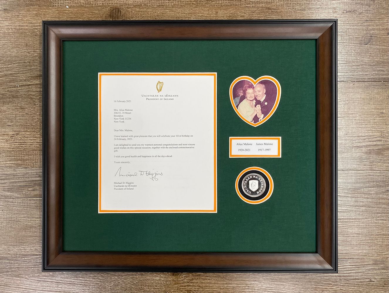 A framed letter with a picture of a couple in a heart shaped frame