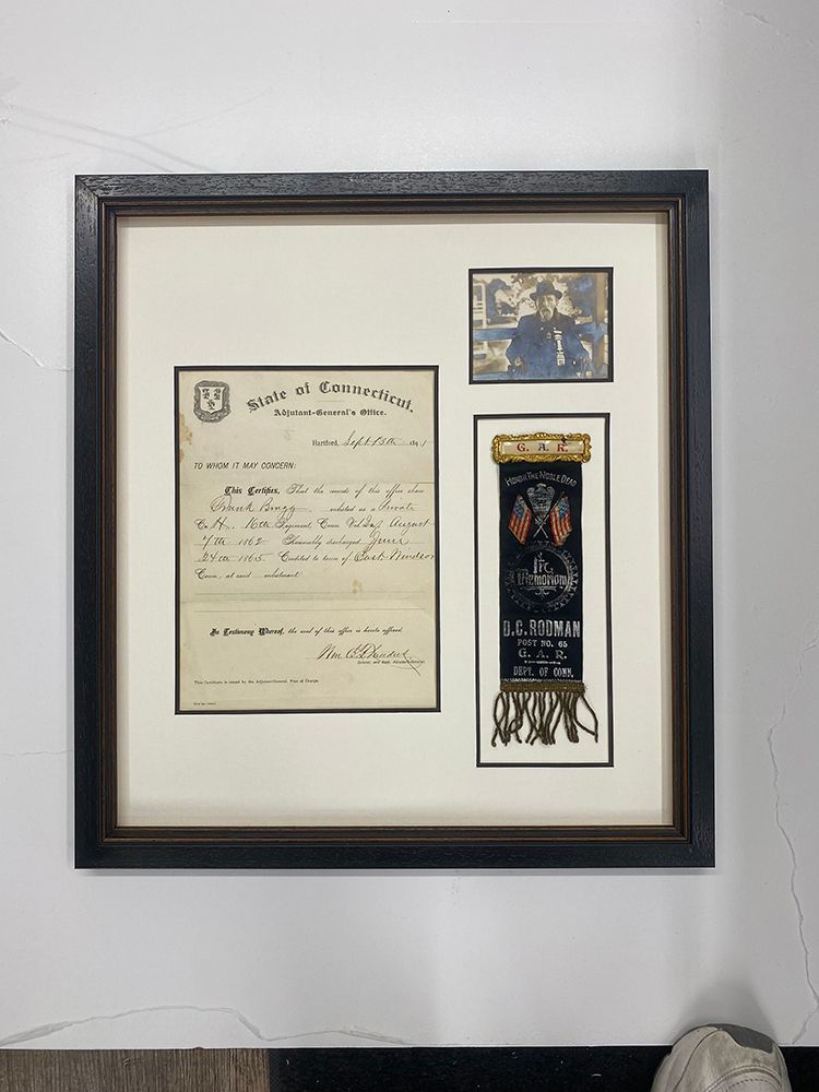 A framed letter and ribbon are hanging on a wall