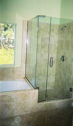 A bathroom with a tub and a shower with a glass door.