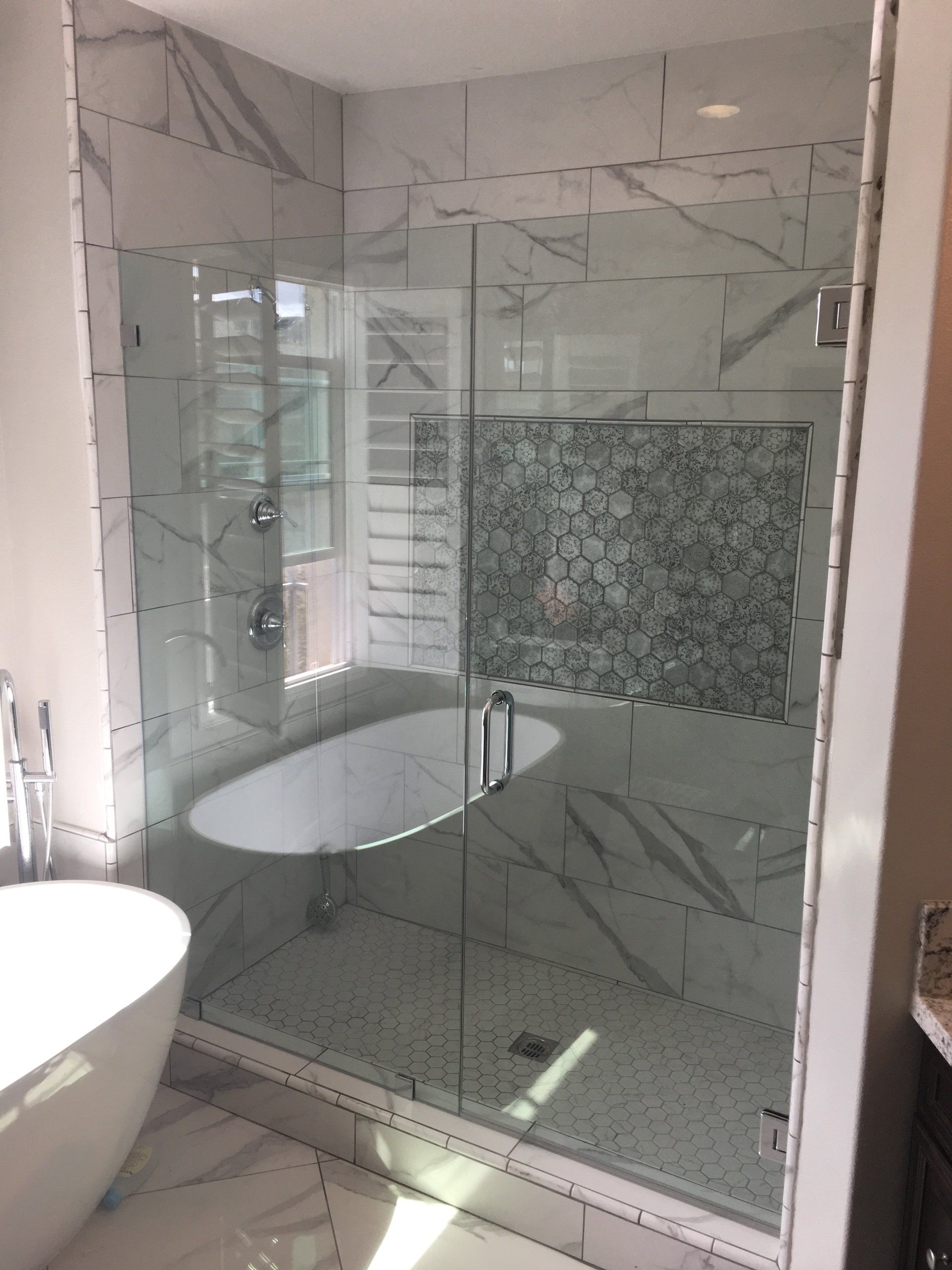 A bathroom with a bathtub and a walk in shower